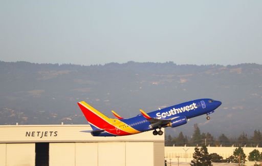 Southwest Airlines Boeing 737-700 takes off from San Jose Airport at sunrise with Santa Cruz mountains in the background