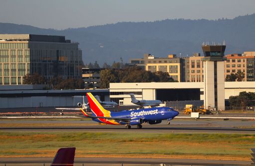Southwest Airlines Boeing 737-700 taking off with control tower and Santa Cruz mountains in the background at San Jose airport