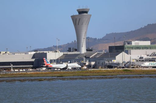 American Airlines Embraer E175 on runway at San Francisco airport with control tower and Sign Hill in view