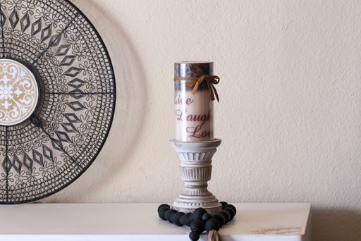 A closeup of candle and mandala on a white table in home interior design