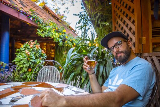 A beautiful shot of the tourist in glasses drinking beer near Mayan ruins in Copan Ruinas, Honduras