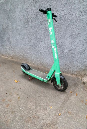 An electric scooter for rent on the background of a grunge wall