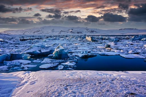 A beautiful shot of the Jokulsarlon glacial lagoon under a pink cloudy sky during the sunset in winter
