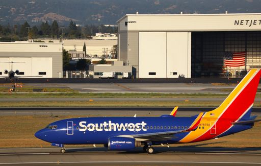 Southwest Airlines Boeing 737-700 taxiing with NetJets hangar in view
