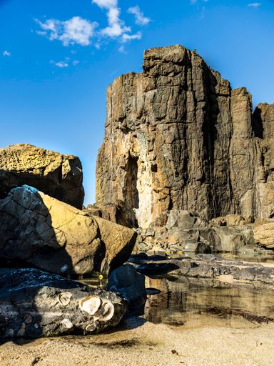 Majestic rock formations under a vibrant blue sky at Bombo Quarry, New South Wales, showcasing natural beauty and geological features.