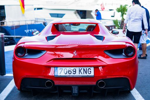 Puerto Banus, Spain: August 19 2021: Rear view of a red modern sport car Ferrari parked at the marina