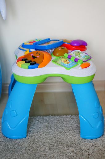 A  vertical shot of a Fisher-Price education toy table with different buttons