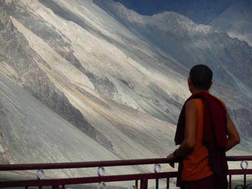 A person looking at rocky hills from a balcony on a sunny day