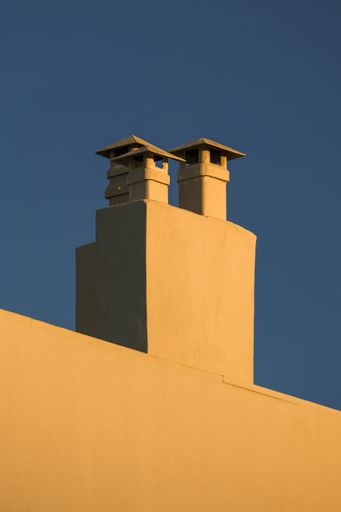 A vertical shot of the chimneys against the blue sky