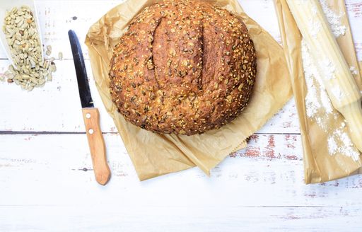 A loaf of tasty bread with seeds on a brown paper