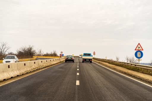 Several cars on the road in traffic in Targoviste, Romania captured from the windshield