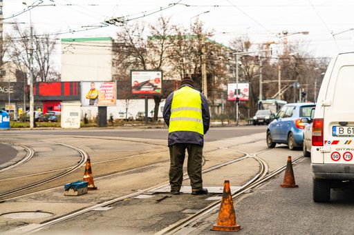A worker arranging traffic cone on tram railway in Bucharest, Romania