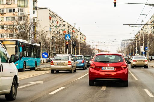 Several cars on the road in traffic in Targoviste, Romania captured from the windshield