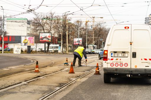 A worker fixing tram tracks on a road in Bucharest, Romania