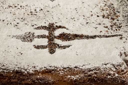 A closeup shot of a beautiful cross pattern drawn on the snowy ground
