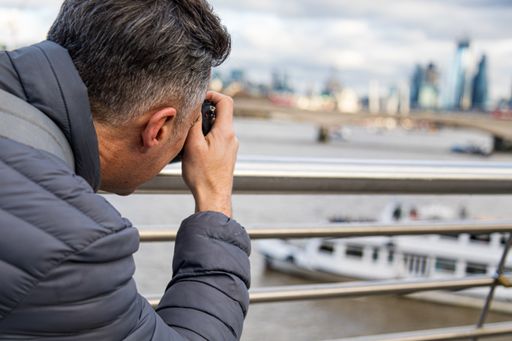 A shallow focus shot of a person taking pictures in London with a blurred background