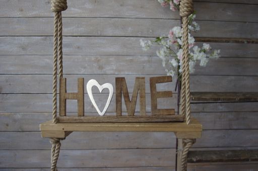 A Home with wooden letters against a wooden wall