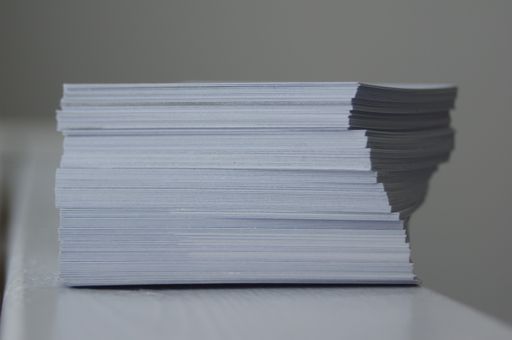 A selective focus shot of a pile of white business cards against a blurred background