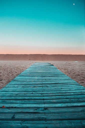 A vertical shot of a wooden way on the sunset sky background