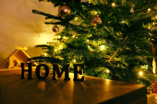 A beautiful shot of the word home on a table with a Christmas tree in the background
