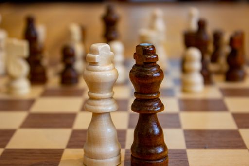 A closeup shot of black and white king chess pieces on a chessboard