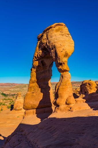 Delicate Arch in Arches National Park, Utah, stands against a vibrant blue sky, showcasing the stunning natural rock formation.