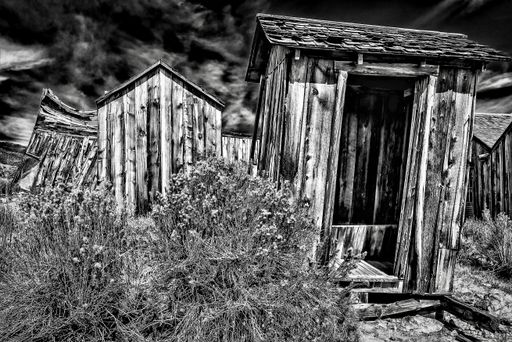 A grayscale shot of wooden abandoned houses at Bodie State Historic Park in California
