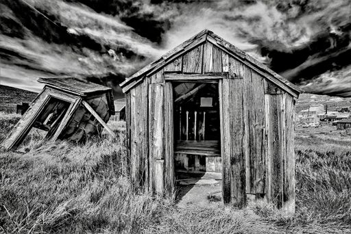 A grayscale shot of a wooden abandoned house at Bodie State Historic Park in California