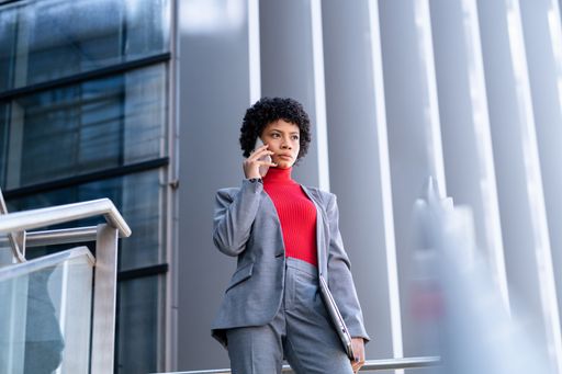 A young African-American businesswoman talking on the phone in a business building