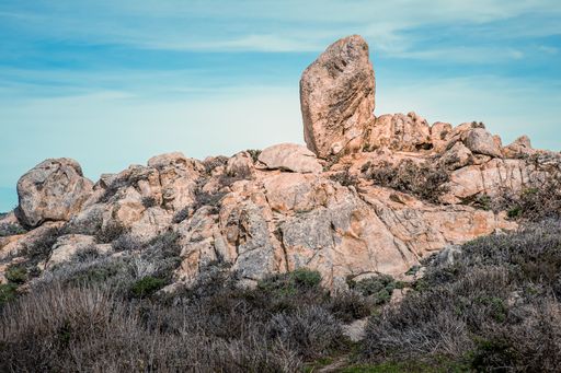 A beautiful shot of big rocks at Big Sur, California with a blue sky in the background
