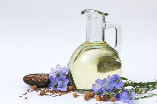 flax oil bottle with flowers and seeds isolated on white background
