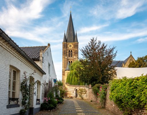 A scenic view of a St Michael abbey church in a white village Limburg, The Netherlands