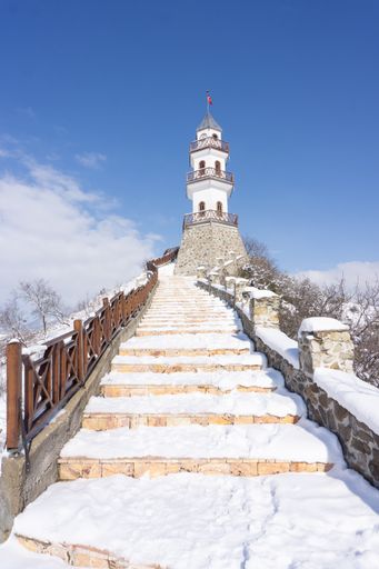 A vertical shot of snowy stairs leading to the Victory Tower (Zafer Kulesi) in Goynuk, Bolu, Turkey