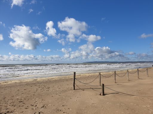 A mesmerizing view of camber sands beach in Sussex during daytime under cloudy blue sky