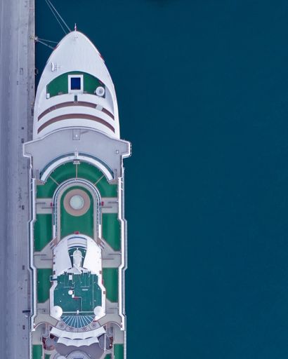 A top view of an elegant cruise ship on a calm coast