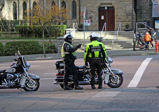 A rear shot of two policemen standing in the street with motorbikes in Vancouver, British Columbia, Canada