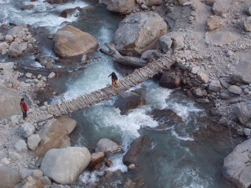 An aerial view of people crossing the wooden bridge over the Ganga river