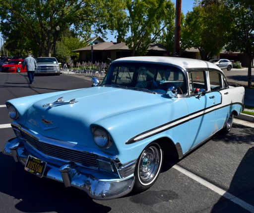 A front view photo of a Classic Baby Blue and White Top Chevy Bel Air Car with Original Large Bird Hood Ornament at Car Show in Fresno, USA