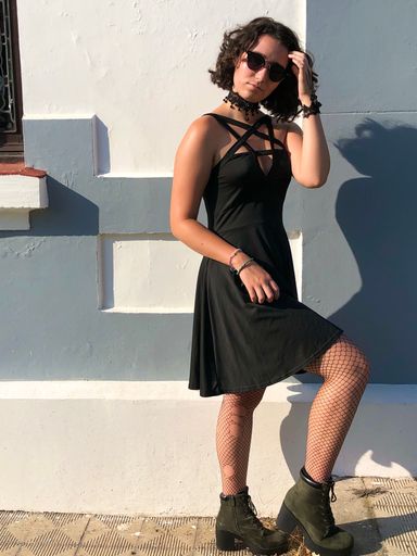 A young Caucasian lady standing near the building and posing for the camera.