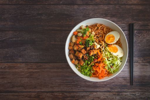 A top view of homemade ramen soup on a wooden table.