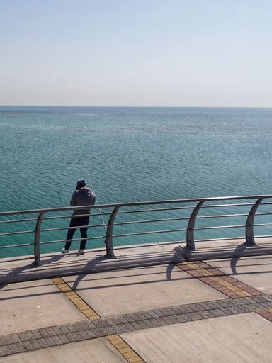 A vertical shot of a traveller on the seashore