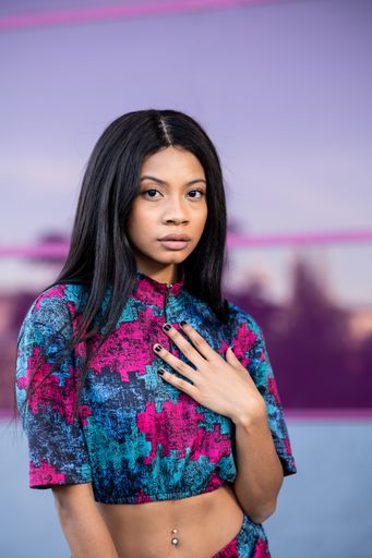 A young sexy attractive African American model with long black hair posing for a photoshoot outdoors