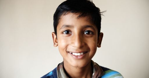 A close up shot of South Asian boy looking and smiling indoor in India