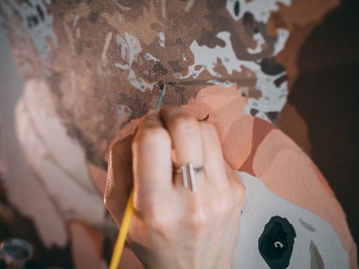A closeup shot of an artist painting on the canvas