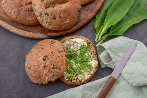 A top view of whole grain bread rolls with wild garlic