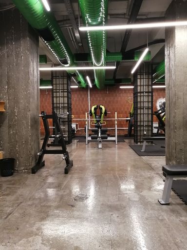 A vertical shot of an empty gym with columns and bright lighting