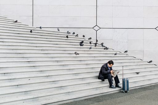 A man sits alone on the stairs of la Defense Arch, at the heart of the Paris financial district.