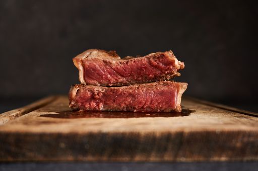 A closeup shot of a rare steak on a wooden table