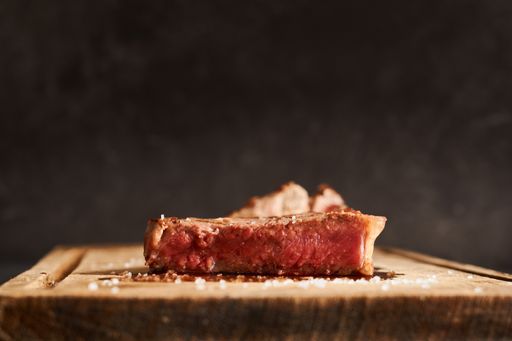 A closeup shot of a rare steak on a wooden table