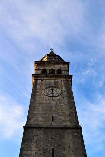A vertical shot of a clock tower on a sunny day
